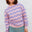 Person wearing a pink and purple striped sweater against a white background