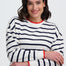 Woman wearing a striped sweater with red accents on a white background