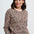 Woman wearing a leopard print sweater against a plain background
