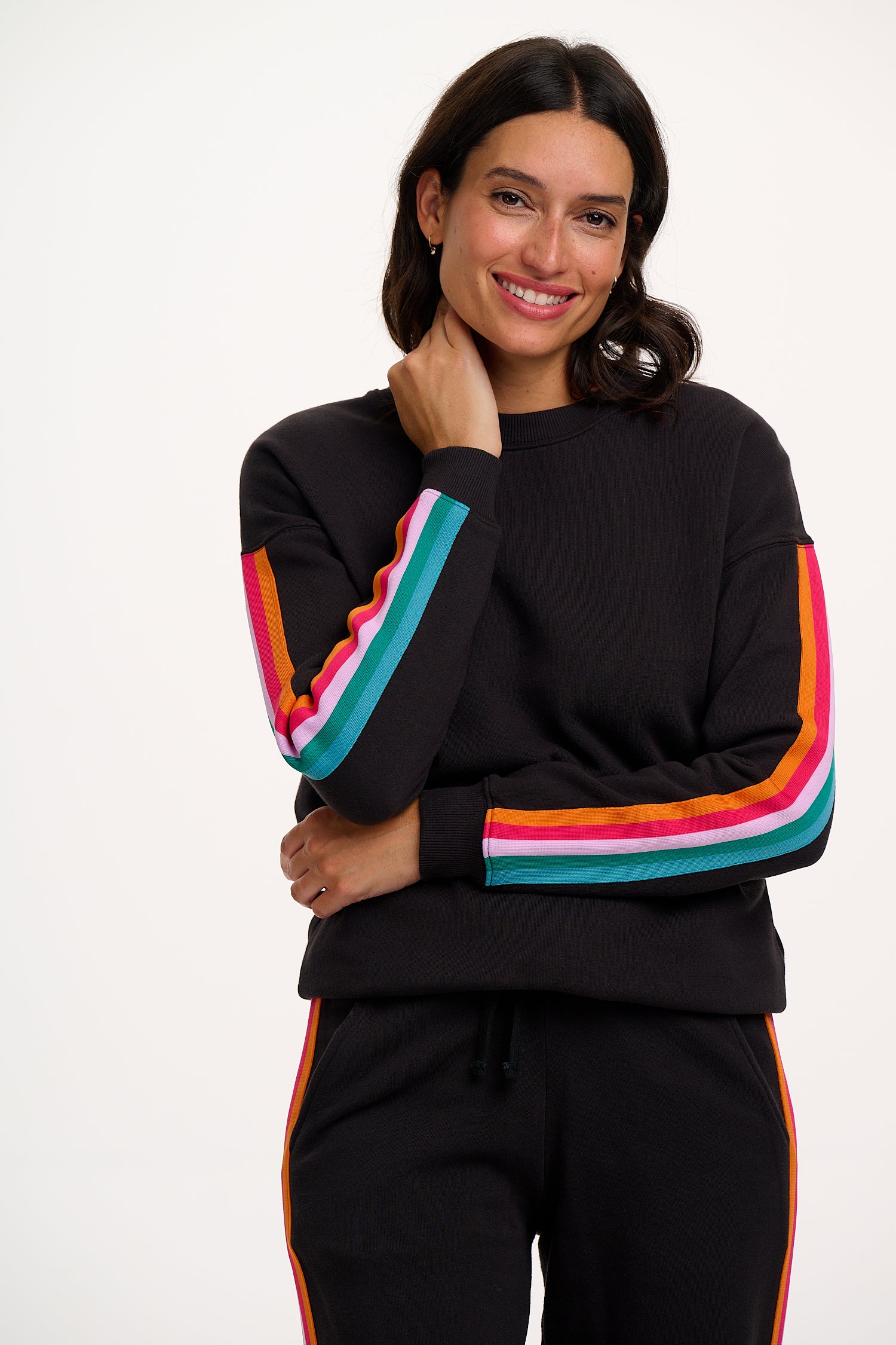 Woman wearing a black outfit with colorful stripes on a white background
