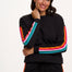 Woman wearing a black outfit with colorful stripes on a white background