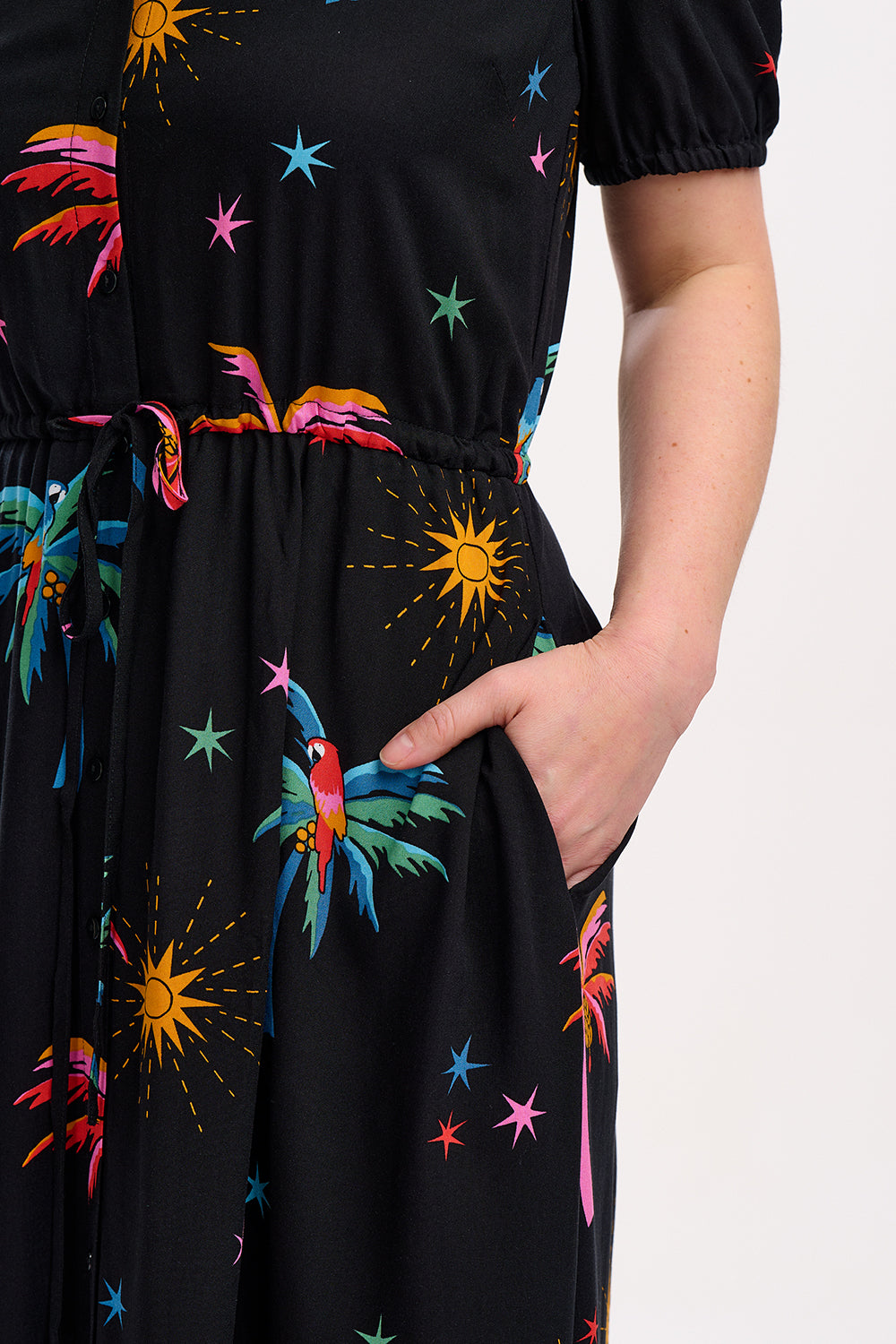 A black maxi shirt dress with a colorful floral pattern featuring palm trees and sunshade motifs.