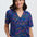 Woman wearing a colorful patterned shirt and pants on a white background