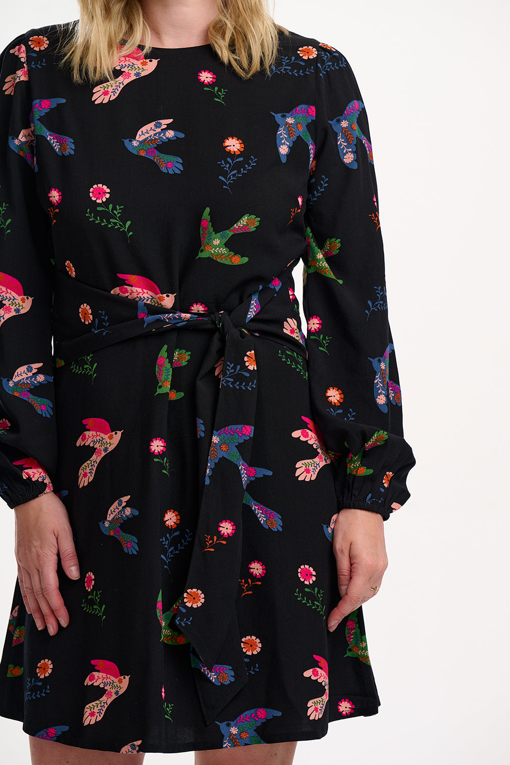 Black dress with colorful floral patterns worn by a person