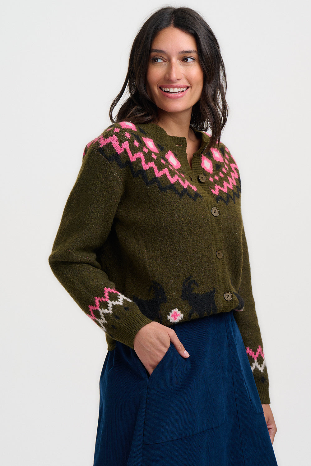 Woman wearing a green sweater with pink floral patterns on a white background