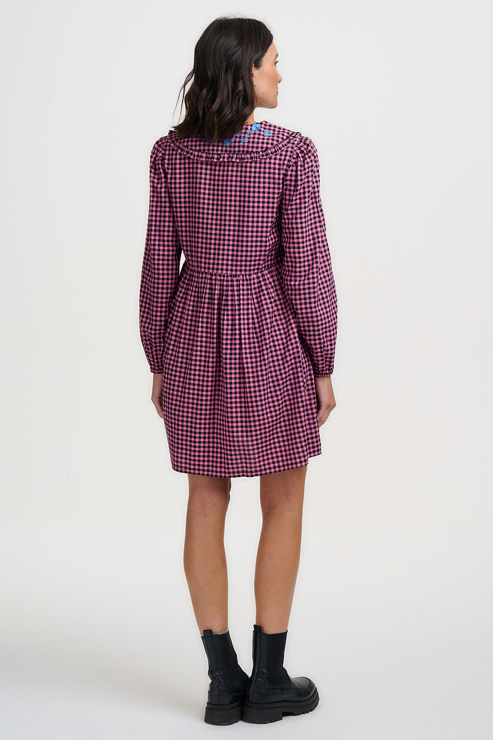 Woman wearing a purple checkered dress on a white background