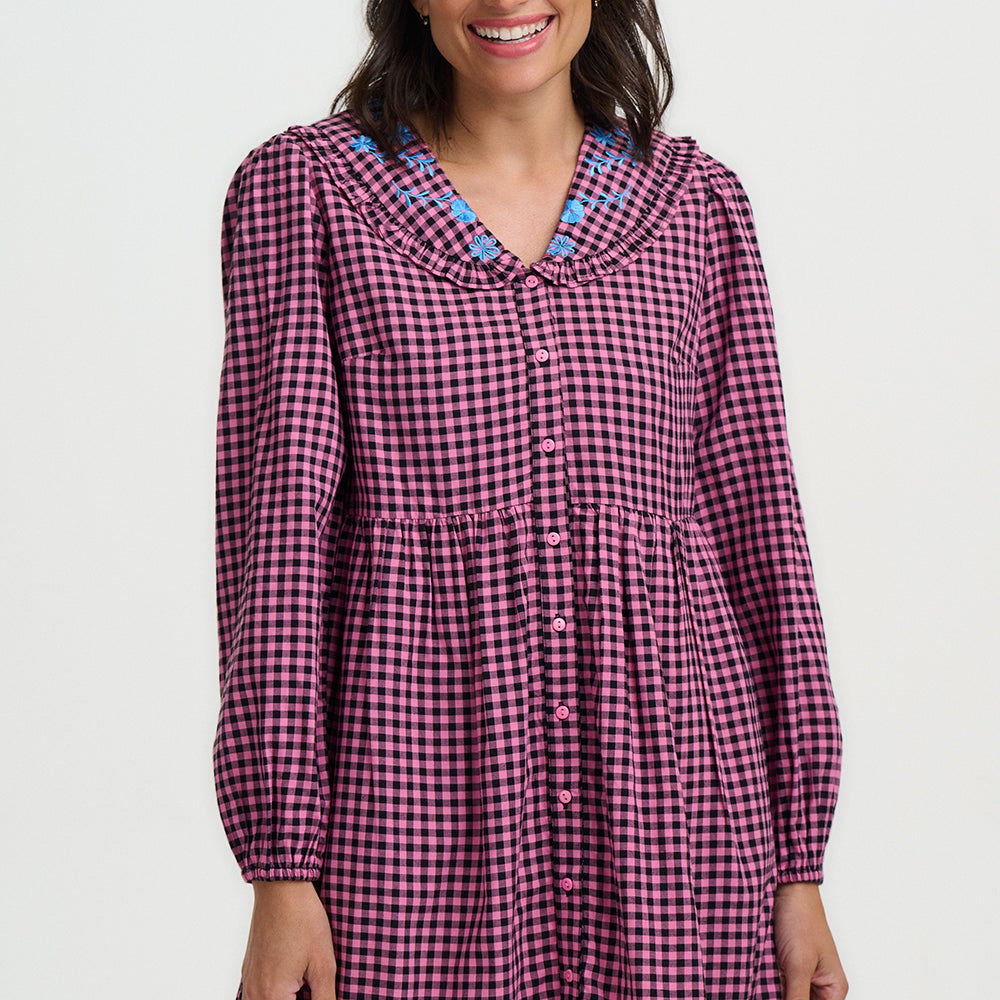Woman wearing a purple checkered dress with a white background