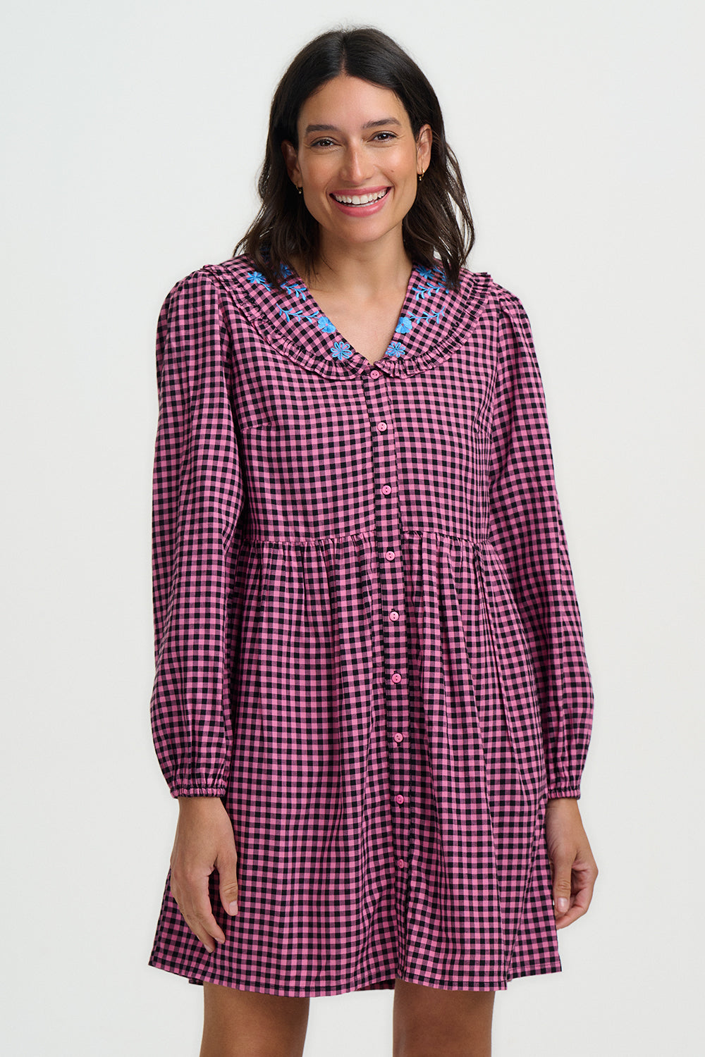 Woman wearing a purple checkered dress with a white background