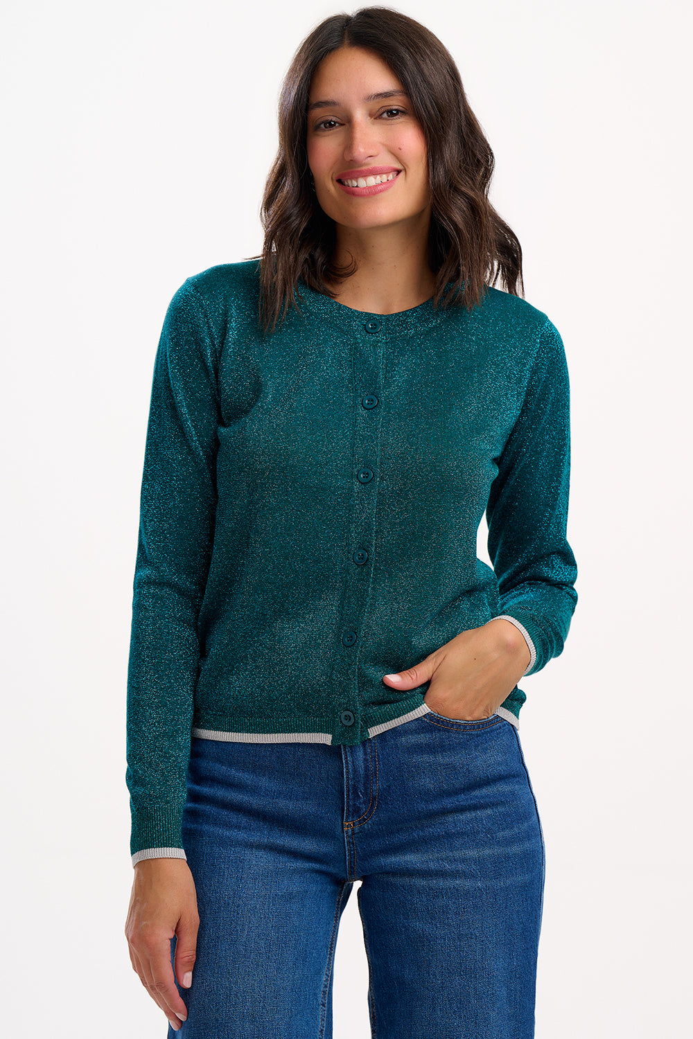 Woman wearing a teal cardigan and blue jeans on a white background