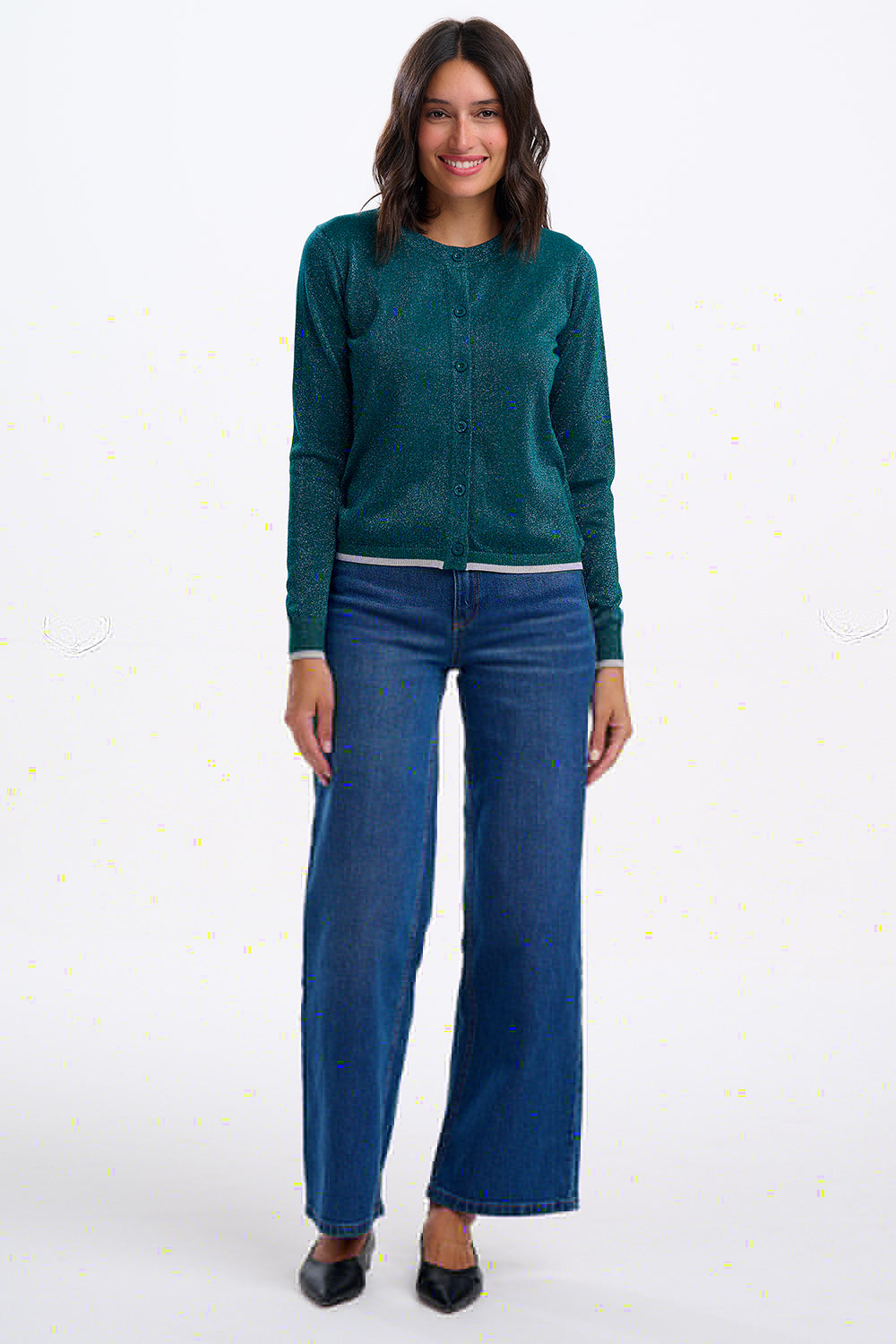 Woman wearing a teal sweater and blue jeans on a white background
