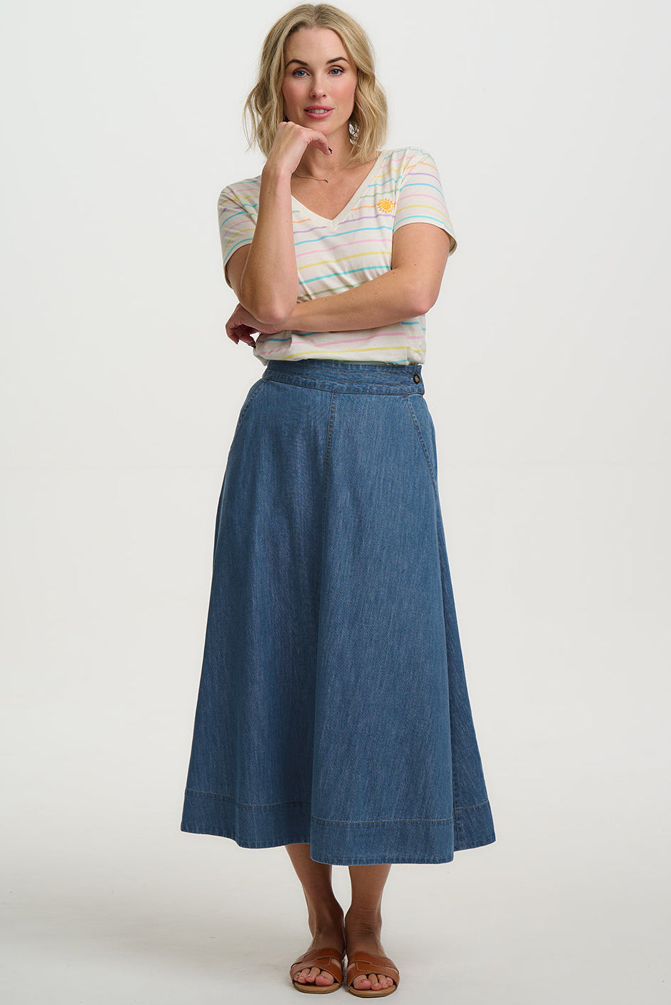 Woman wearing a striped shirt and blue denim skirt on a white background