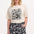 A person wearing a beige top with a black floral folk print and matching black and white patterned shorts with an elastic waistband and drawstring.