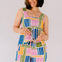 Woman wearing a colorful patterned romper against a plain background