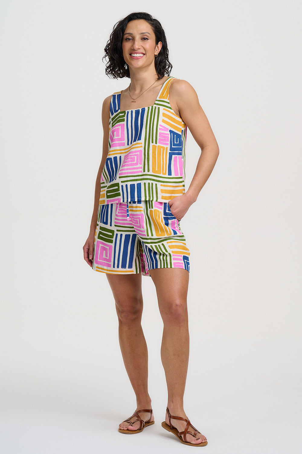 Woman wearing a colorful patterned romper on a white background