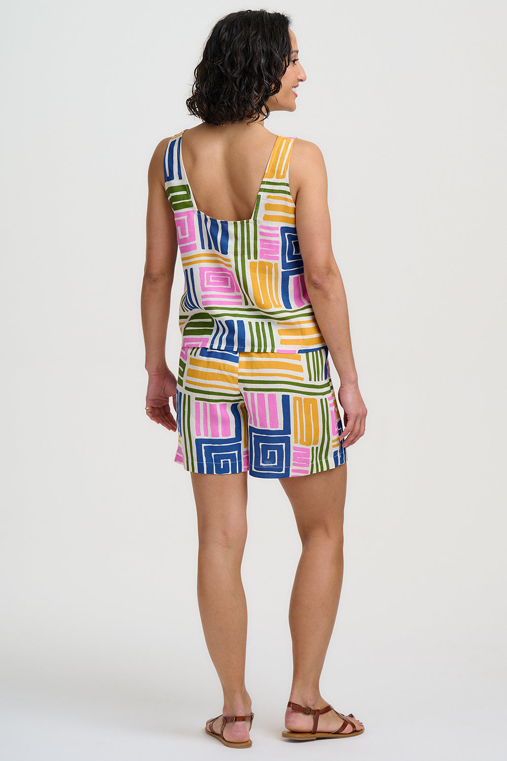 Woman wearing a colorful patterned dress on a white background