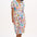 A model wearing an off-white midi shirt dress with a Jungle Tile print, featuring a button placket and puff sleeves.