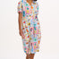 A model wearing an off-white midi shirt dress with a Jungle Tile print, featuring a button placket and puff sleeves.