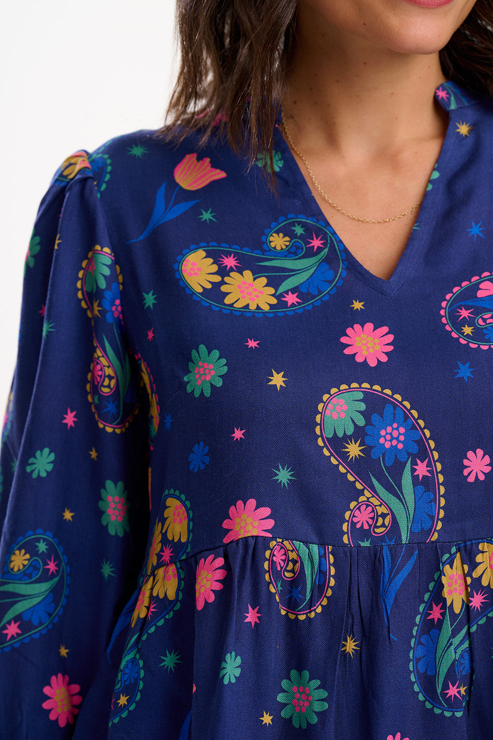 Navy blue dress with colorful floral and paisley patterns on a white background