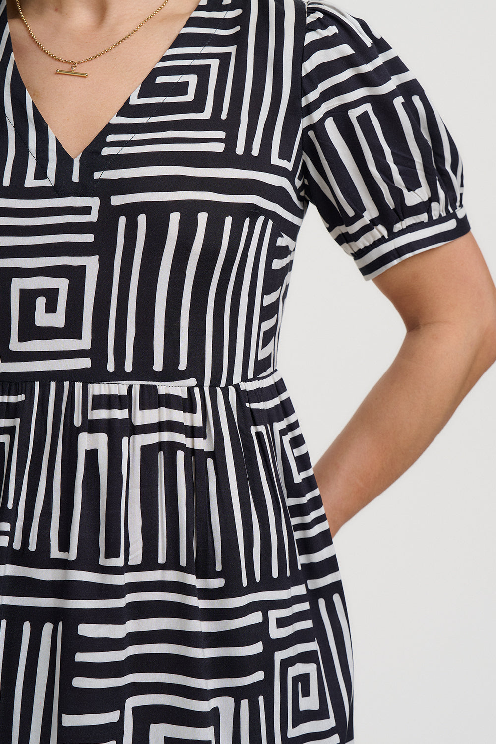 Black and white patterned dress worn by a person on a plain background