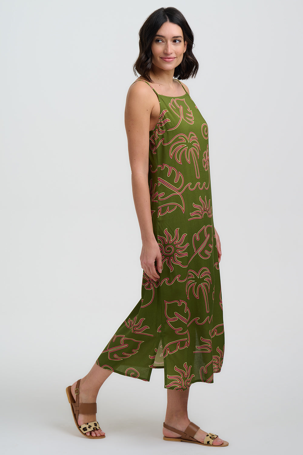 Woman wearing a green dress with floral pattern on a white background