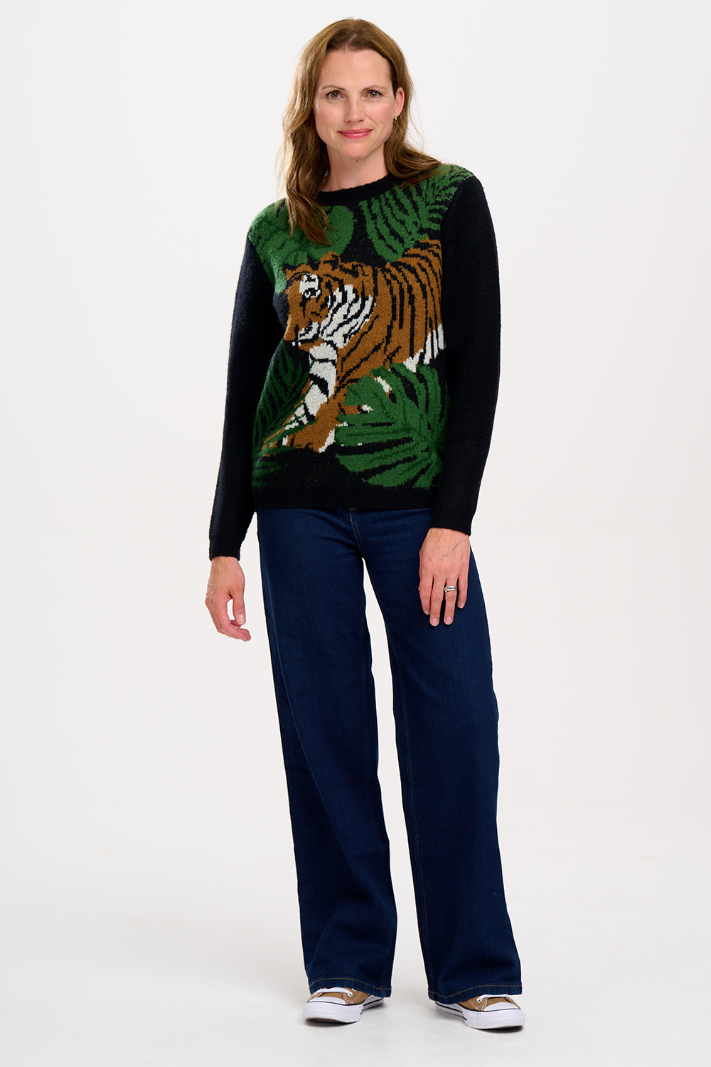 A woman  wearing a black, tiger, and palm design jumpers with a crew neck and long sleeves.