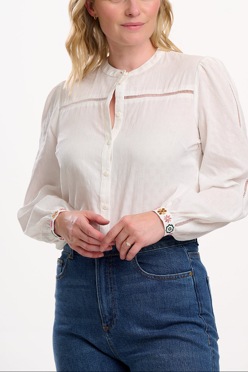 Woman wearing a white blouse and blue jeans on a white background