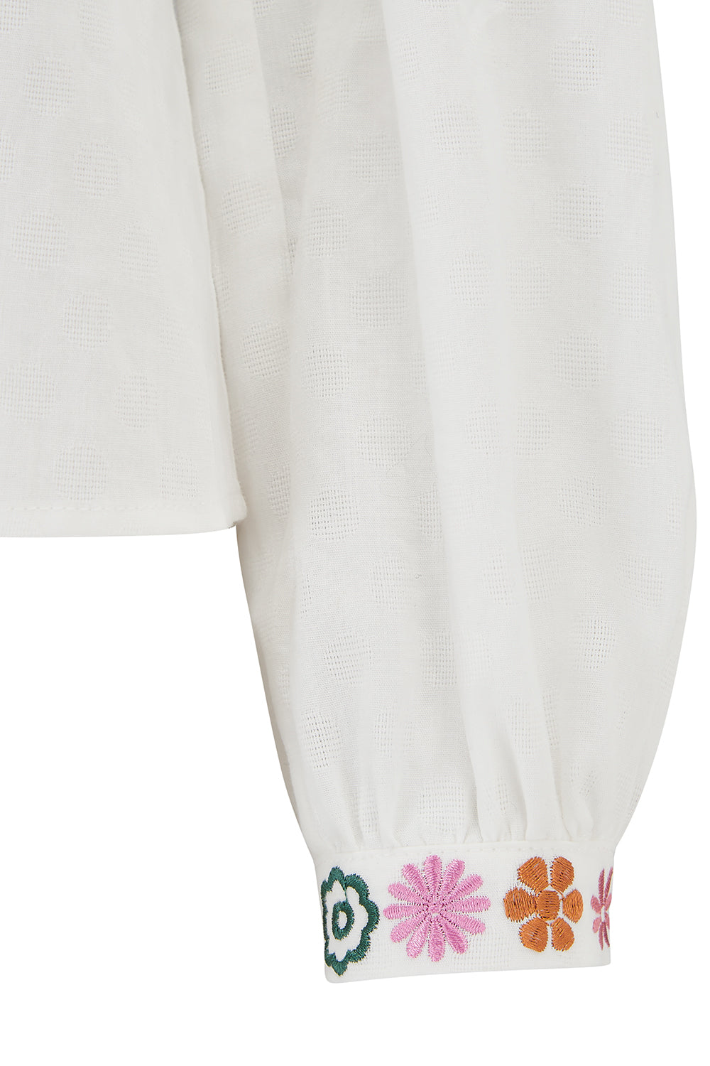 White garment with colorful floral embroidery on cuffs against a white background