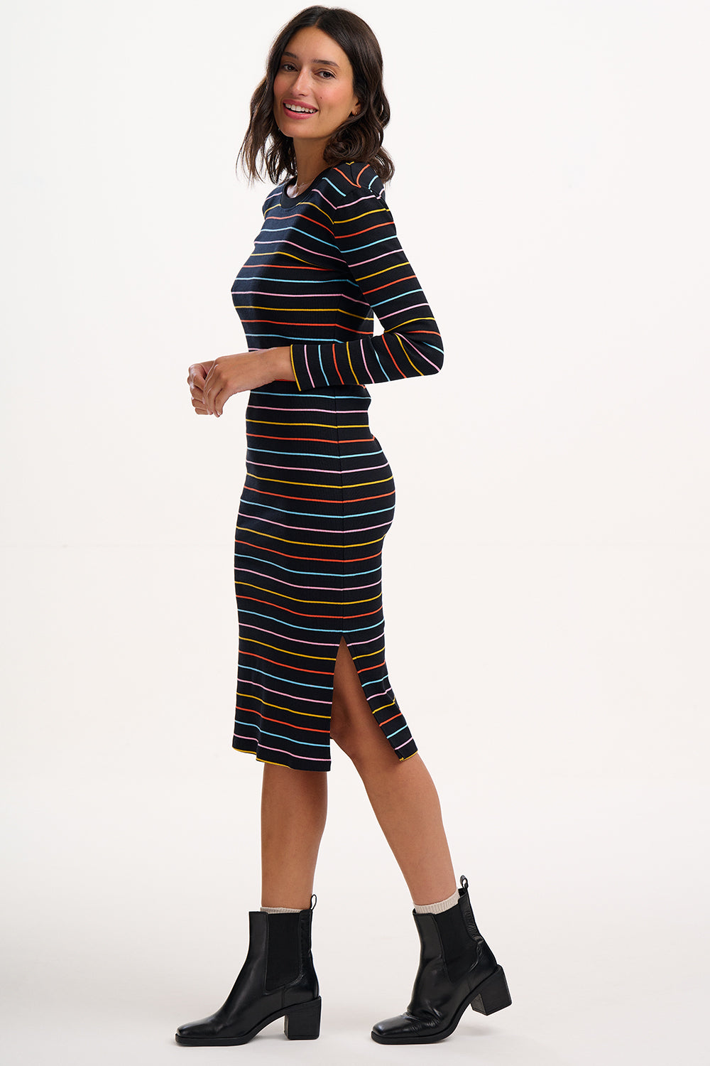 Woman wearing a striped dress with black boots on a white background