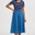Woman wearing a blue dress with a striped top on a white background