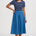 Woman wearing a blue dress with a striped top on a white background