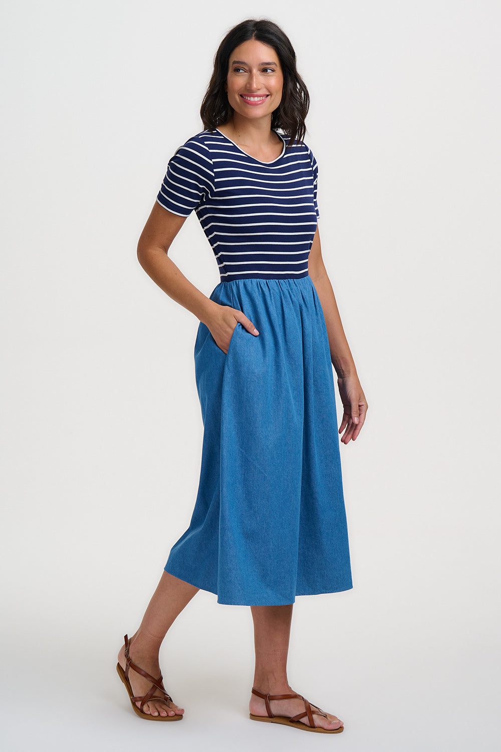 Woman wearing a blue striped shirt and blue skirt on a white background