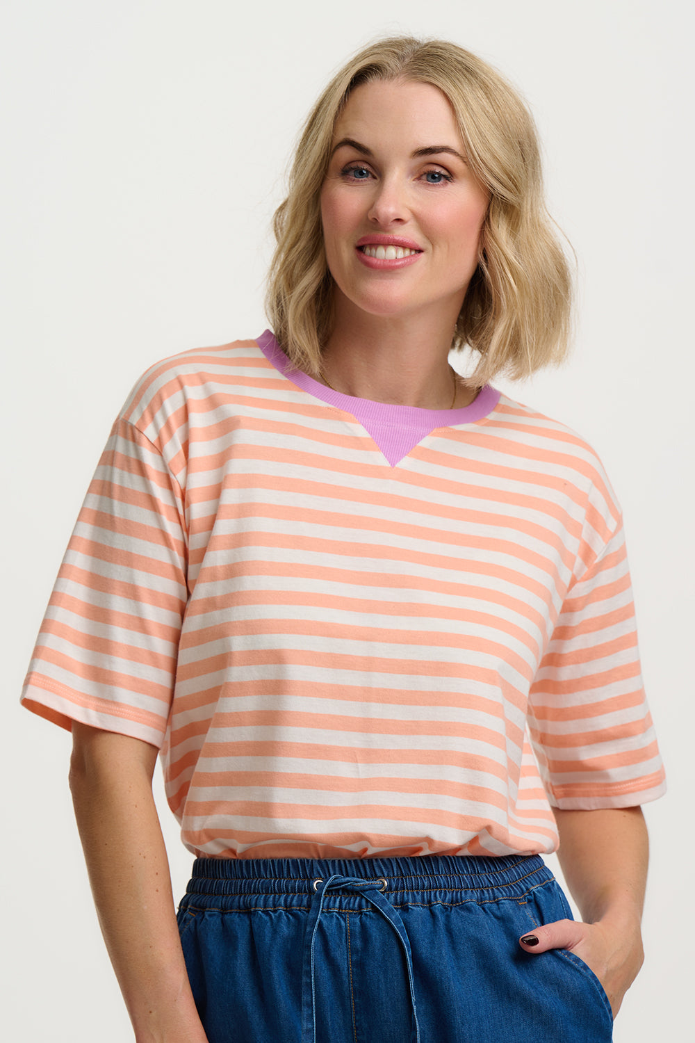 Woman wearing a striped shirt with a plain background
