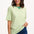 Sugarhill Brighton model wearing a green and white striped shirt with blue jeans on a white background