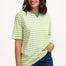 Sugarhill Brighton model wearing a green and white striped shirt with blue jeans on a white background