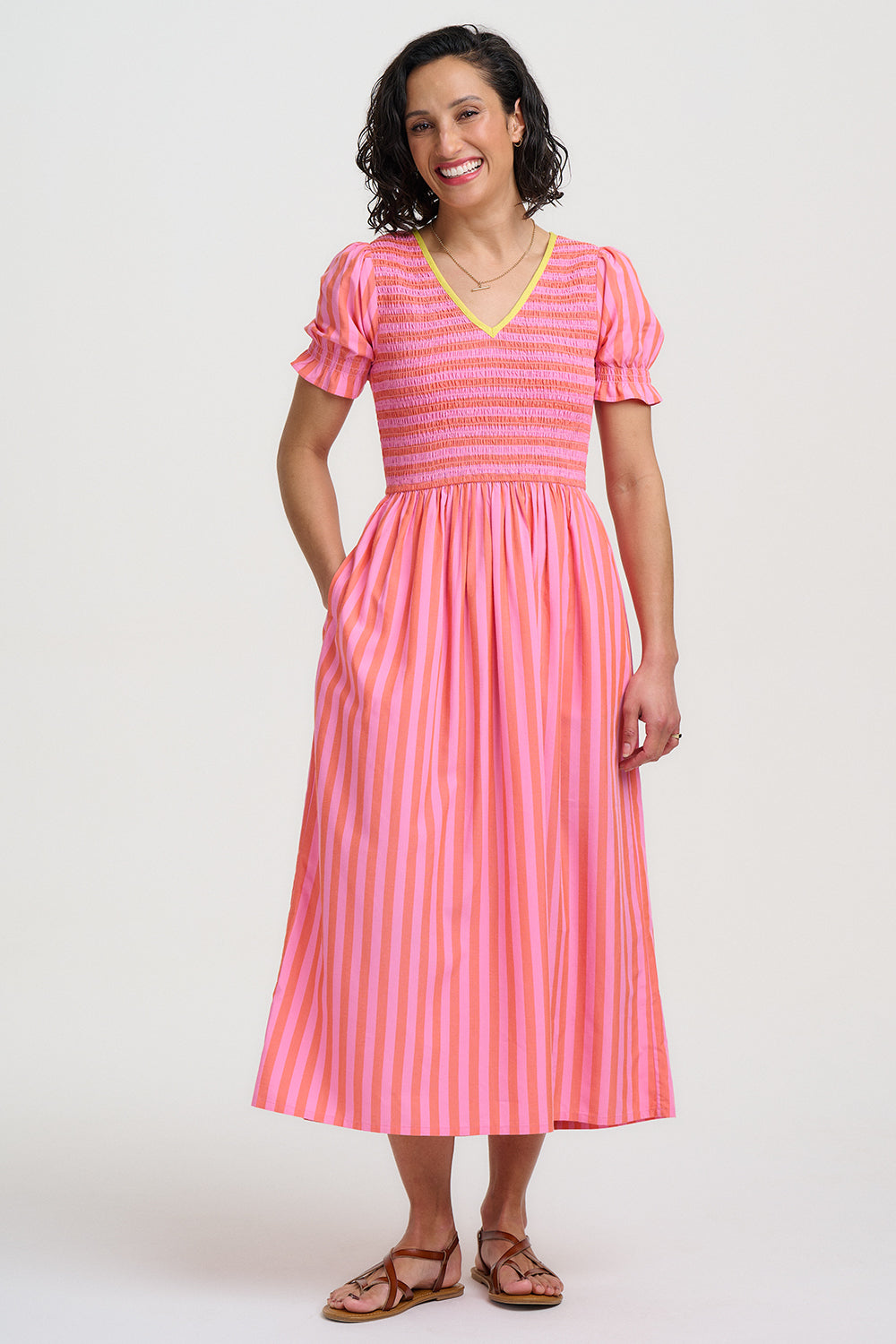 Woman wearing a pink and white striped dress on a white background