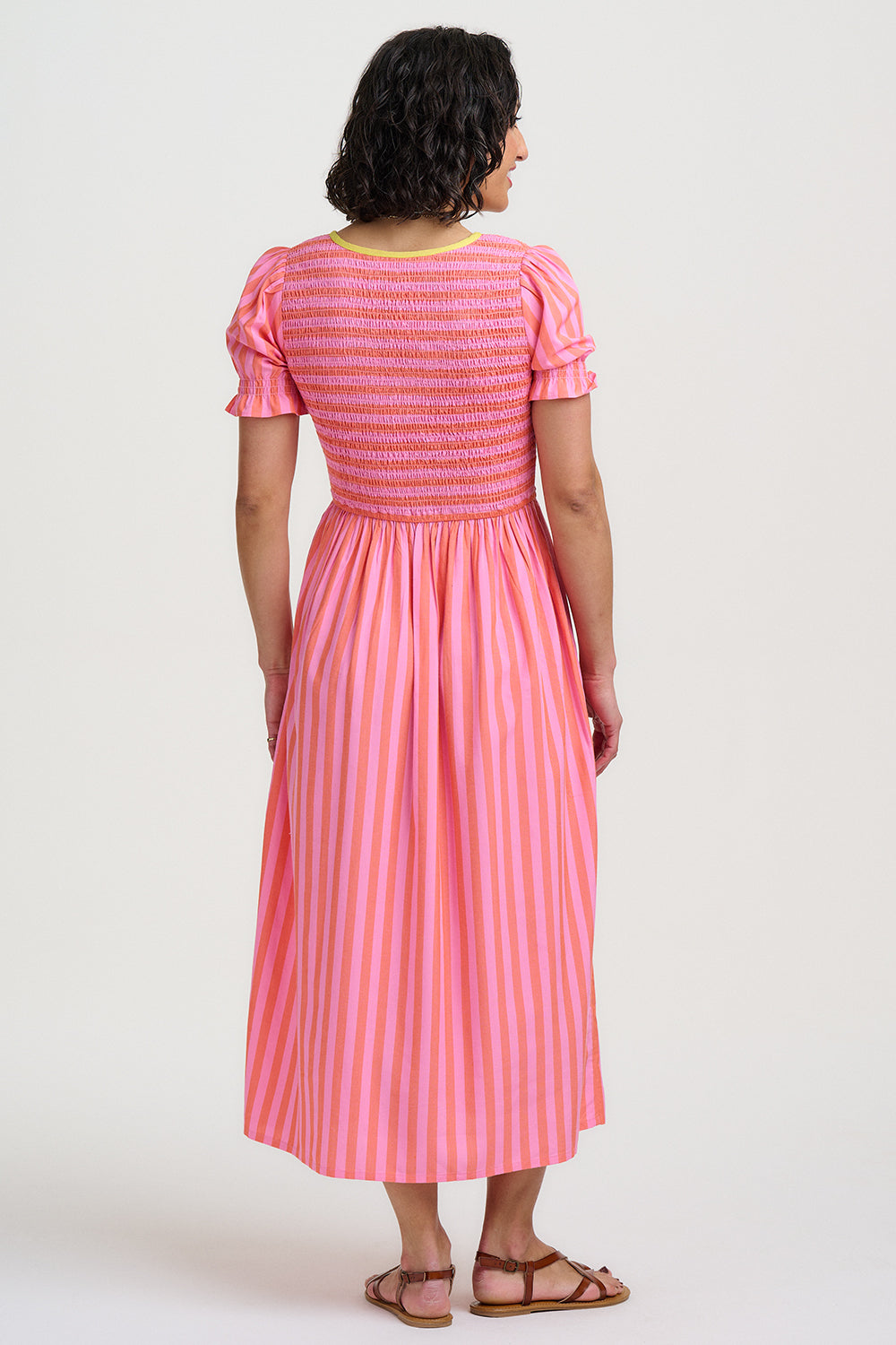 Woman wearing a pink dress with a white background