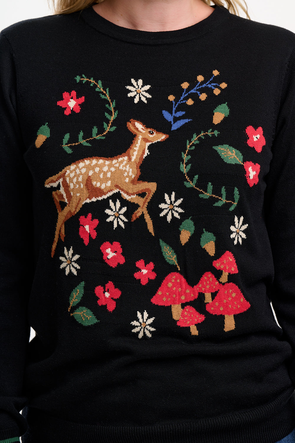 Black sweater with deer and floral embroidery on a dark background