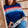 Woman in a striped sweater reading a book in a wicker chair.
