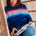 Woman in a striped sweater reading a book in a wicker chair.