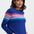 Woman wearing a blue sweater with colorful stripes on a white background