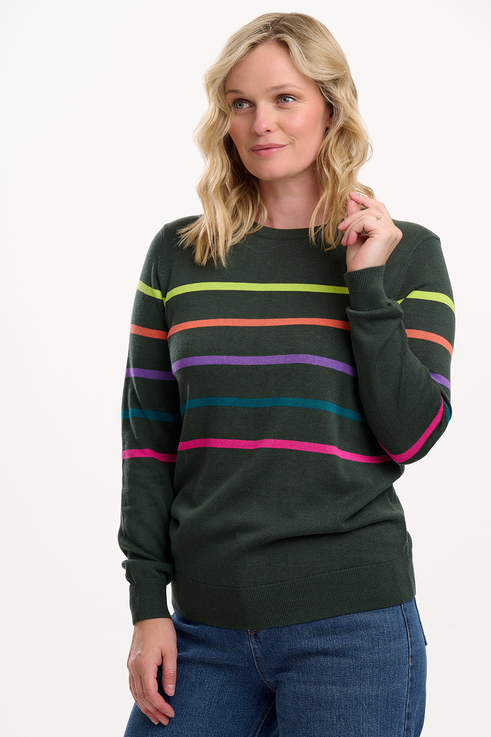 Woman wearing a green sweater with colorful stripes on a white background
