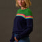 Woman wearing a colorful sweater with a striped pattern against a plain background