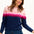 Sugarhill Brighton model wearing a navy jumper with pink gradient stripes, paired with jeans, standing against a white background.