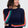 Person wearing a navy sweater with colorful stripes and blue jeans on a white background