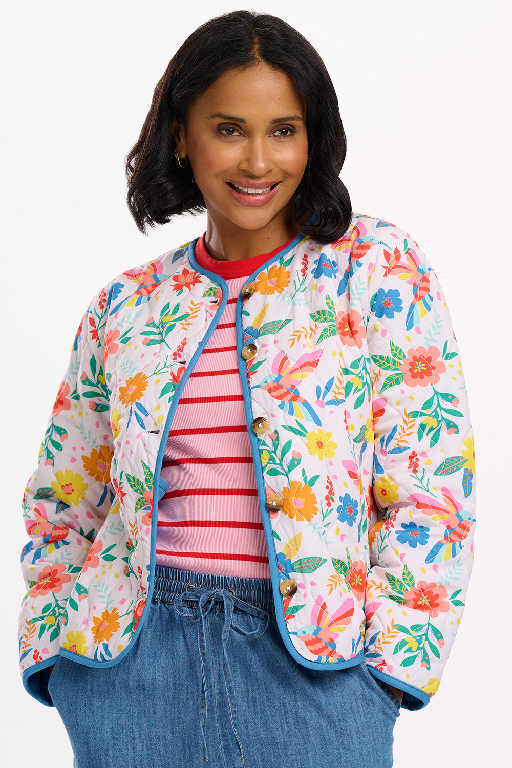 A woman wearing an off-white quilted jacket with a Tropical Hummingbird print, featuring front pockets and a round neckline.
