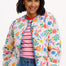 A woman wearing an off-white quilted jacket with a Tropical Hummingbird print, featuring front pockets and a round neckline.