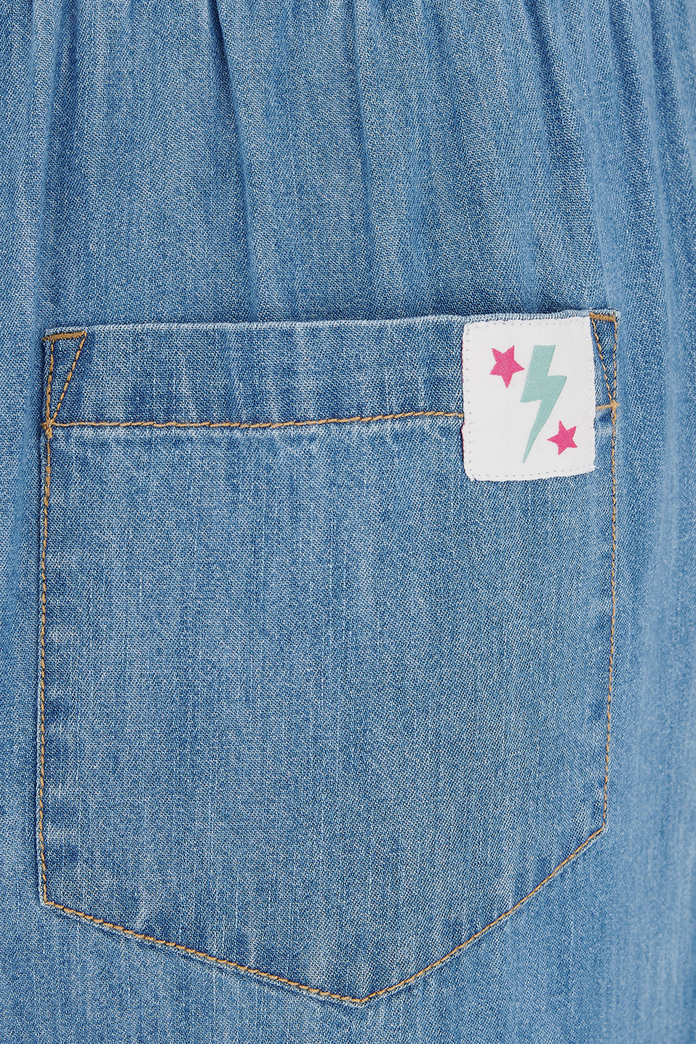 Close-up of a blue denim pocket with a colorful label.