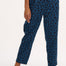 A woman modeling Romney trousers with a petrol navy color and a leopard print design.