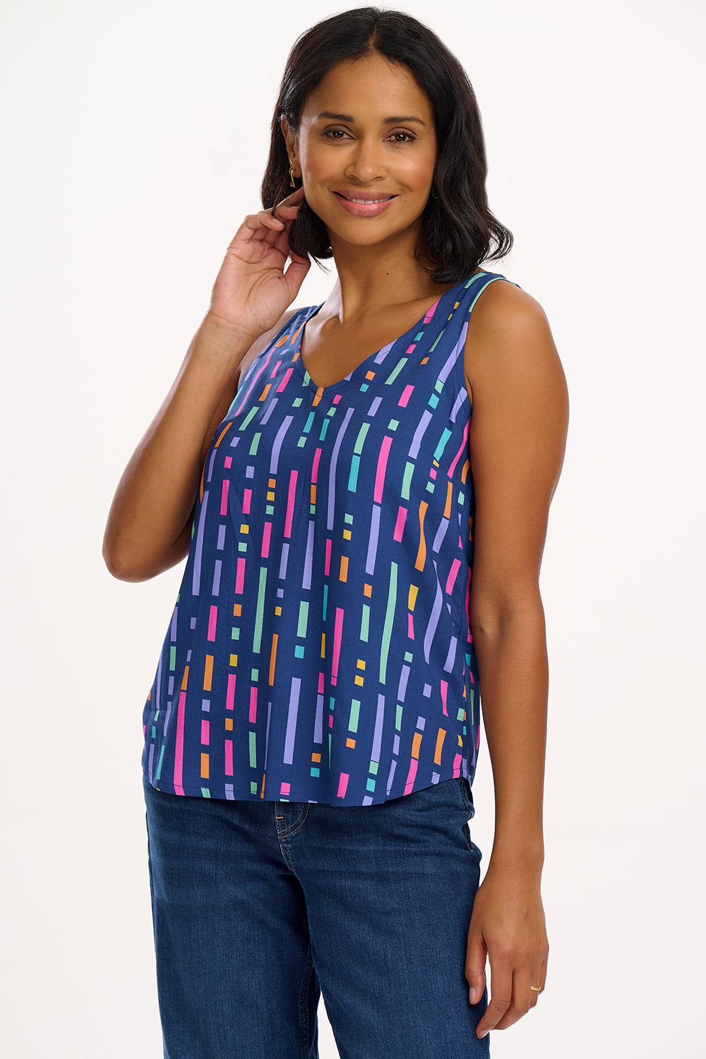 A model wearing a sleeveless blue vest top with a geometric pattern of broken lines in shades of purple, pink, green, and orange.