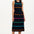A model wearing a sleeveless, striped midi dress in black with bands of pink, green, blue, and orange. She is also wearing pink strappy sandals.